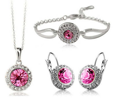 Luxury jewelry set for women featuring a necklace, bracelet, and earrings with pink gemstones.